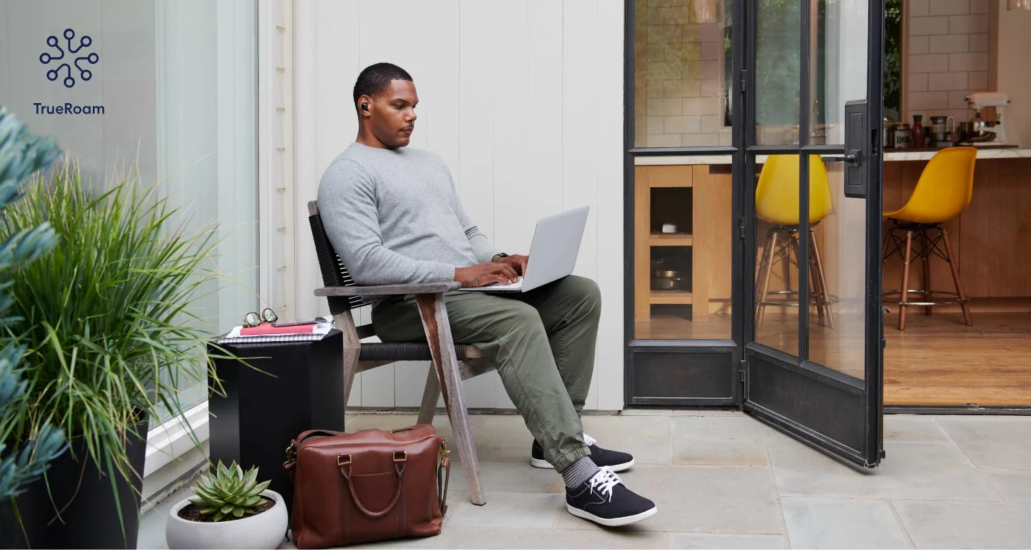 Man with a laptop computer on his lap. sitting on a porch